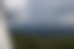 The view from a fire tower of dark mountains, trees, and looming storm clouds.