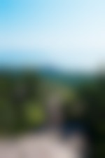 A person standing on a rocky peak overlooking a massive lake.