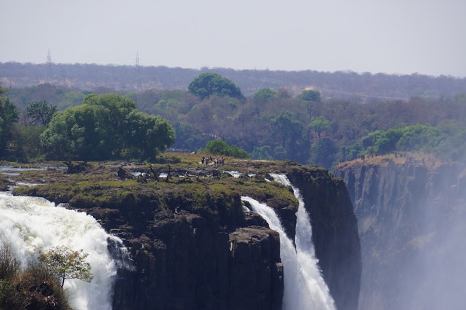 group of people gathered at edge of waterfall