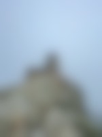 A stone watch tower sits on top of the rocky outcropping