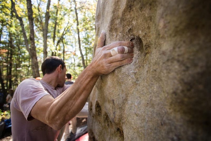A person boulders up a rock face