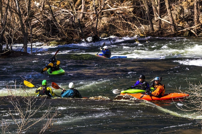 A group of kayakers maneuver the rapids