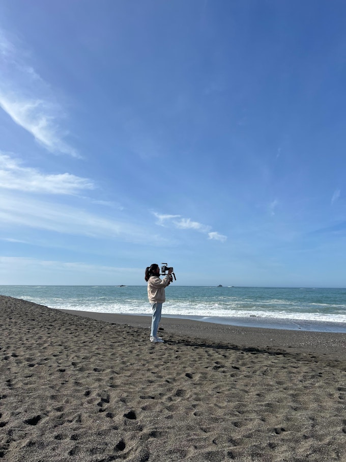 Lauren holds the camera on an empty beach.