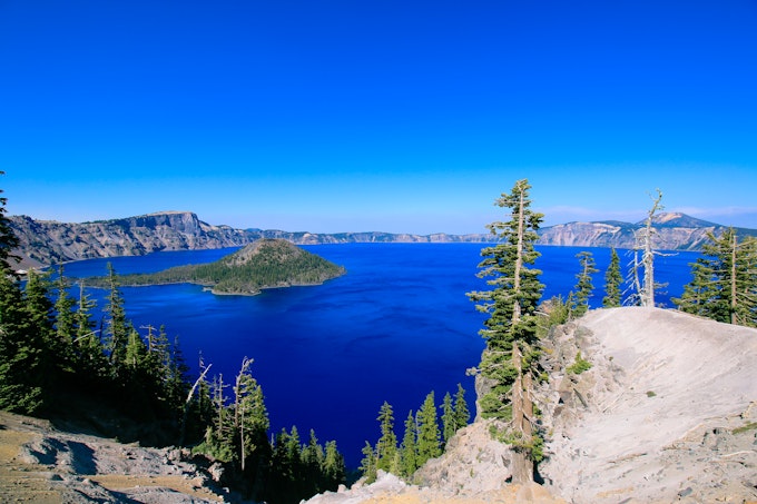 Looking out from a high point over a lake surrounded by mountains.