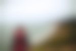 A lone backpacker looks out on the ocean from a coastal ridgeline