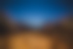 A person is standing on a rocky outcropping in a valley looking out over the canyon.