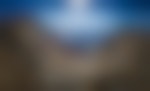 A hiker looks out at the panoramic scenery from a mountain peak